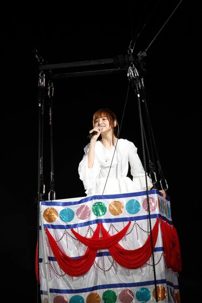 “まりぱんだ”の気球に乗って「帰郷」を歌う篠田麻里子。(c)AKS