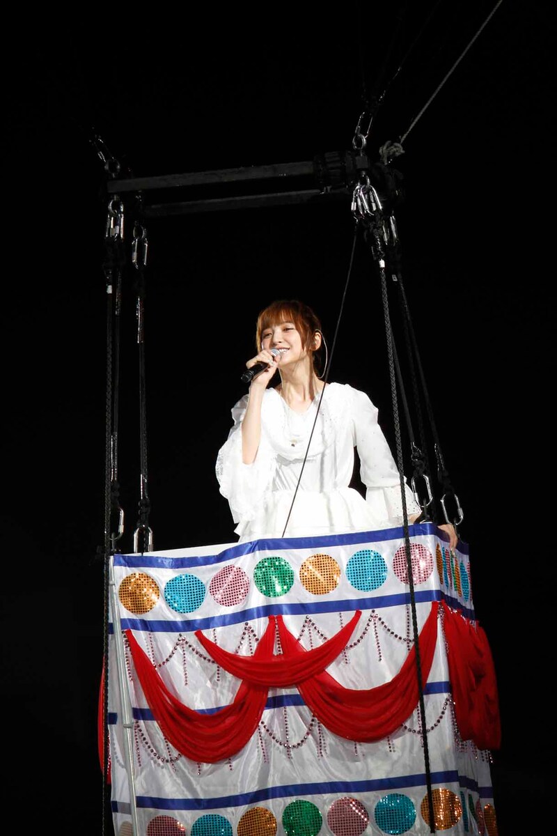 “まりぱんだ”の気球に乗って「帰郷」を歌う篠田麻里子。(c)AKS