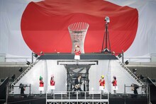 「君が代」を演奏する布袋寅泰とももいろクローバーZ。百田夏菜子は聖火台に上っていく。（撮影：上飯坂一+Z）