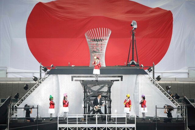 「君が代」を演奏する布袋寅泰とももいろクローバーZ。百田夏菜子は聖火台に上っていく。（撮影：上飯坂一+Z）