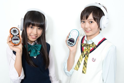 ローランド「ボーカル・トレーナー VT-12」を手にした廣田あいか（写真左）と安本彩花（右）。