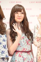 カメラに向かって手を振る白石麻衣。