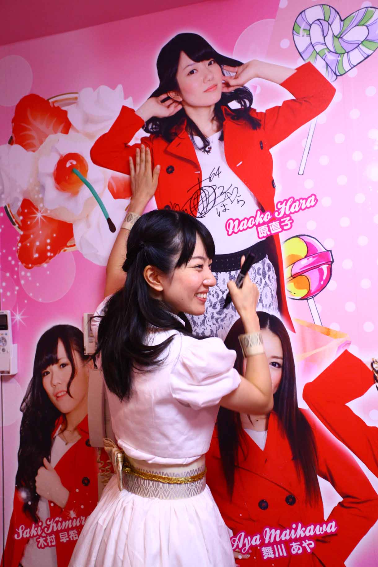 自分の写真にサインする原直子。