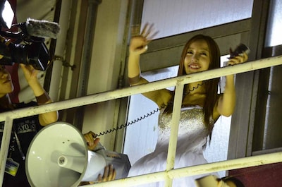 バルコニーから劇場外に集まったファンへあいさつする板野友美。 (c)AKS