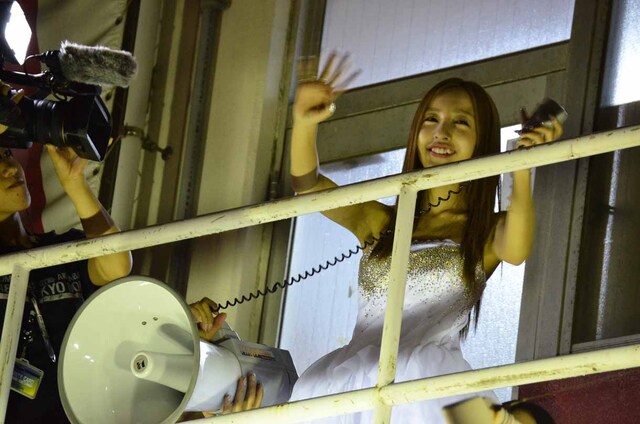 バルコニーから劇場外に集まったファンへあいさつする板野友美。 (c)AKS