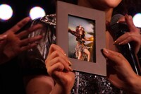 東京ドームコンサートの際に撮られた写真を見せている様子。 (c)AKS