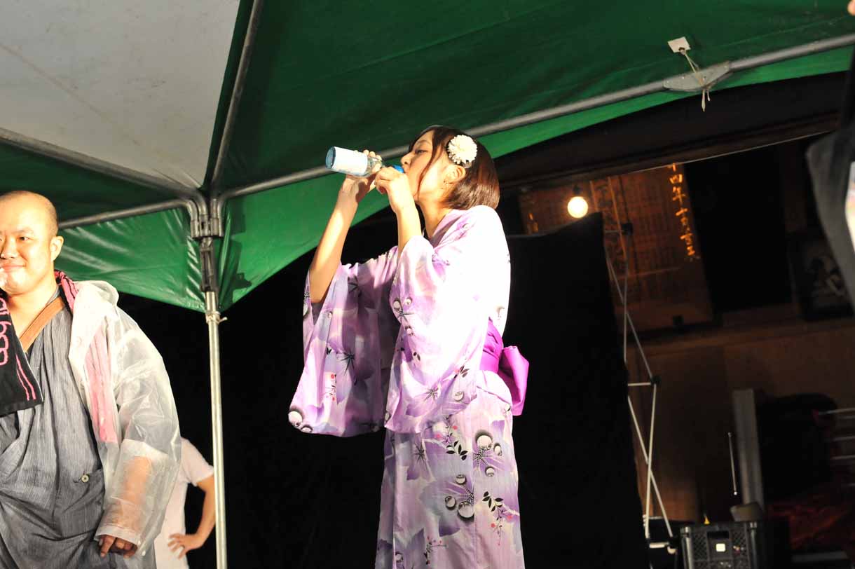 ラムネの早飲みに挑戦する松村くるみ。