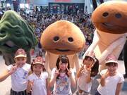 “なめこ帽子”をかぶった観客をバックに行われた記念撮影の様子。