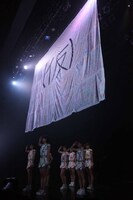 「（仮）」旗の下で敬礼をするアップアップガールズ（仮）。