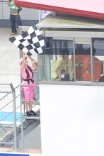 振っていたチェッカーフラッグが屋根に引っかかり、慌てる佐々木彩夏。