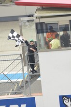 GT300クラス予選タイム終了を告げるチェッカーフラッグを振る有安杏果。