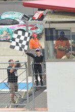 GT300クラス予選タイム終了を告げるチェッカーフラッグを振る高城れに。