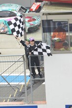 GT300クラス予選タイム終了を告げるチェッカーフラッグを振る有安杏果と高城れに。