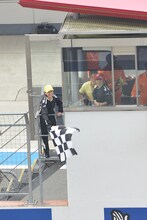 GT500クラス予選タイム終了を告げるチェッカーフラッグを振る玉井詩織。