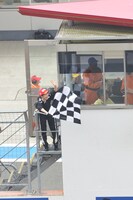 GT500クラス予選タイム終了を告げるチェッカーフラッグを振る百田夏菜子。