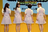 衣装の腰に付いたリボンを見せる乃木坂46。