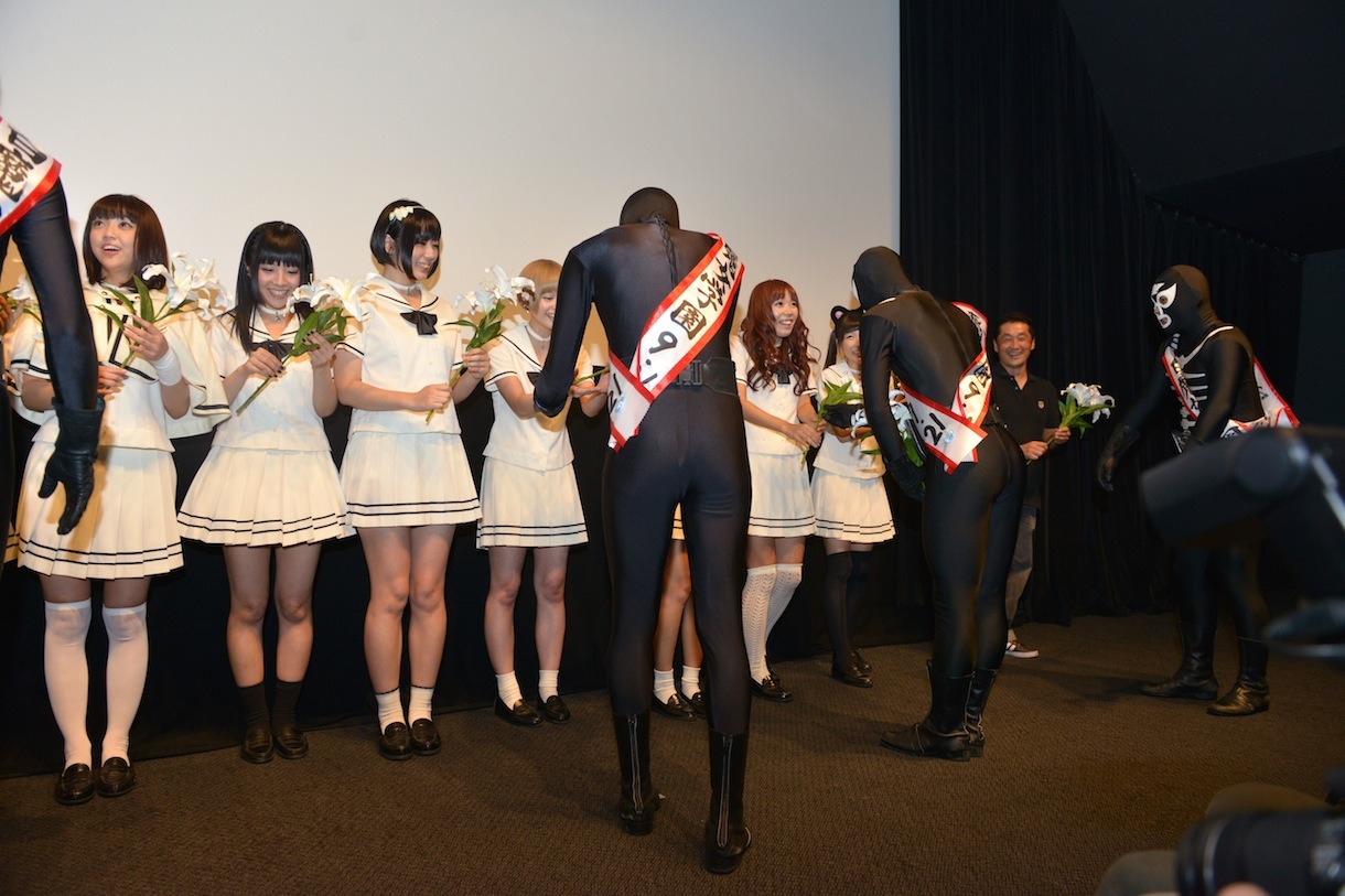 ショッカーに百合の花を手渡される登壇者たち。