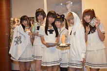 カフェのオススメメニューや「白魔女学園」グッズを持ったでんぱ組.inc。