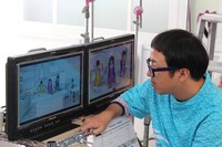 真剣な表情でモニタをチェックするスミス監督。