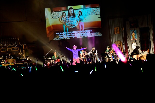 カラオケ風の映像をバックに歌うハナレグミ（Photo by RUI HASHIMOTO -SOUND SHOOTER-）。