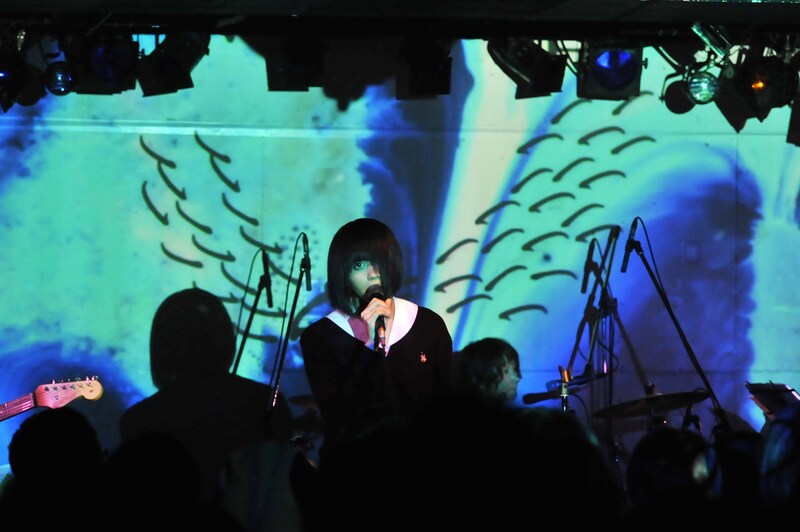 スクリーンに投影される映像をバックに歌う転校生。