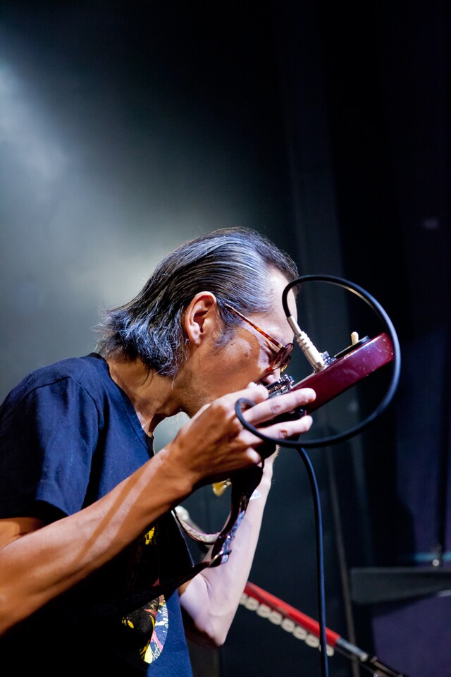歯でギターを弾く和嶋慎治（G, Vo）。(Photo by KASSAI [3PO DESIGN WORKSHOP])