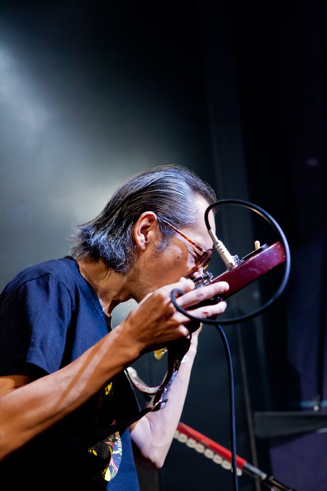 歯でギターを弾く和嶋慎治（G, Vo）。(Photo by KASSAI [3PO DESIGN WORKSHOP])