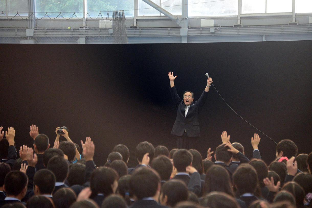生徒とともに万歳三唱する、私立橘学苑中学校・高等学校・杉嵜忠久校長。