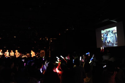 TAKUMIの幼少期の写真を眺める“TAKUMI大好きメンバー＆スタッフ”。