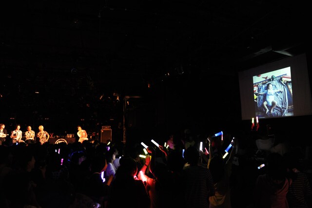 TAKUMIの幼少期の写真を眺める“TAKUMI大好きメンバー＆スタッフ”。