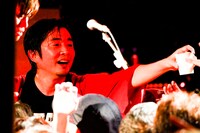 樽酒をふるまう増子直純（Vo）。