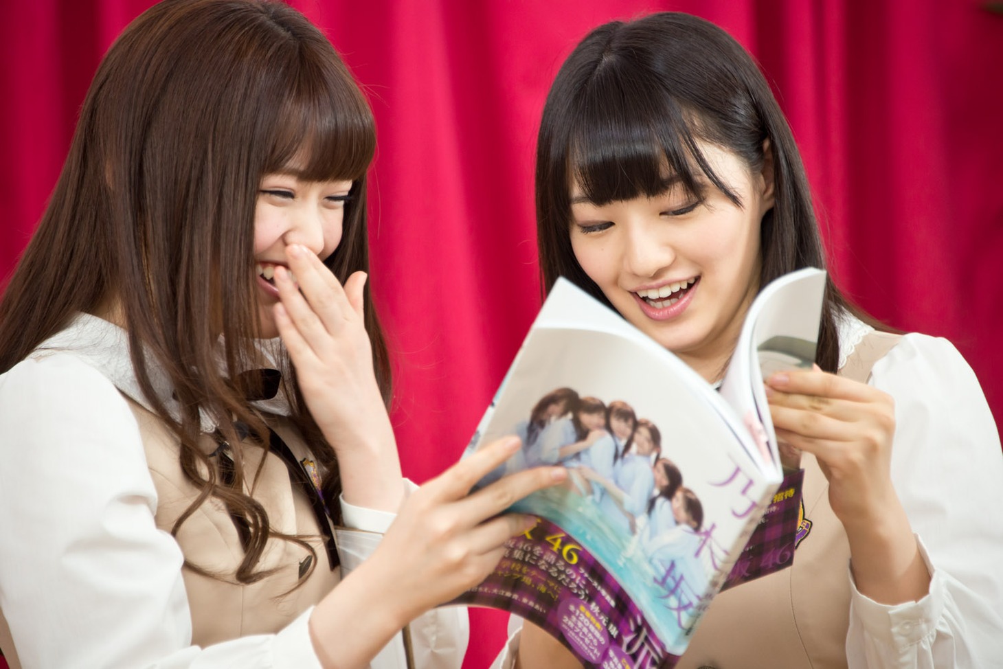 乃木坂46の写真集「乃木坂派」を見る松村沙友理、中田花奈（左から）。