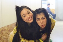 のしかかる伊藤千由李（上）と不服そうな坂本遥奈（下）。