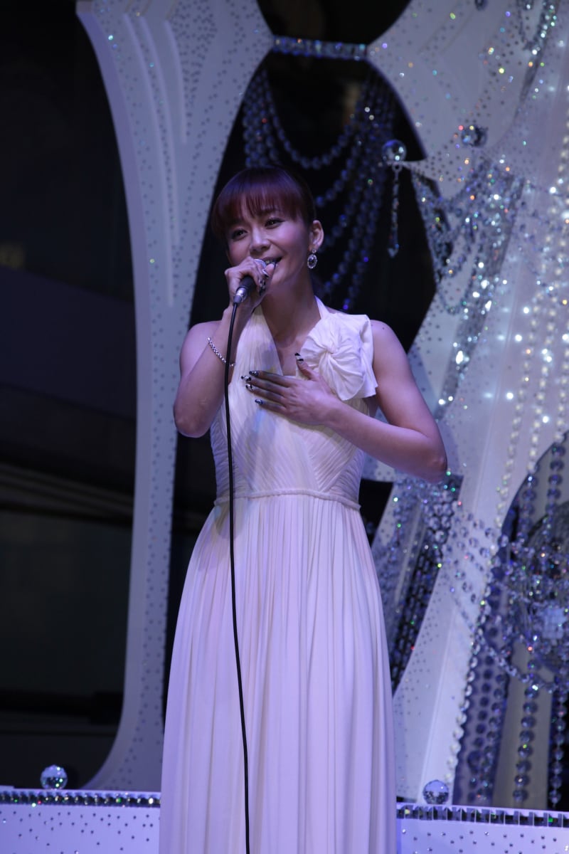 クリスマスツリーをバックに歌う華原朋美。
