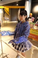 物販コーナーでTシャツを販売する咲良菜緒。