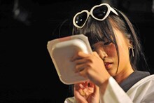 うつろな目でご飯の調理方法を読む根岸愛。