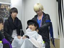 タクヤにレインコートを着せるカイ。