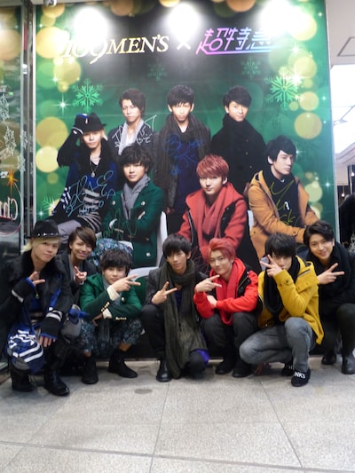 1階エントランスの巨大ポスターと記念撮影する超特急。