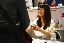 サインを入れたアルバムを手渡す河野マリナ。