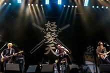 広いステージで寄り添うように集まり演奏する怒髪天。