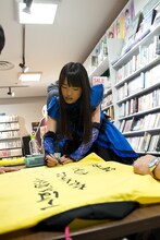 法被にメッセージを書き込む伊藤千由李。