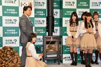 薪ストーブに火を入れる林芳正農林水産大臣と生駒里奈。