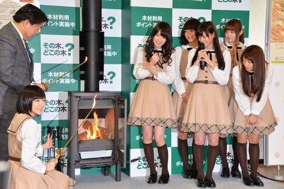 薪ストーブに火を入れる林芳正農林水産大臣と生駒里奈。