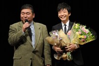 花束を手に満面の笑みを浮かべる星野源。