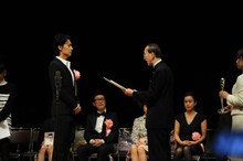 表彰状を受け取る福山雅治。