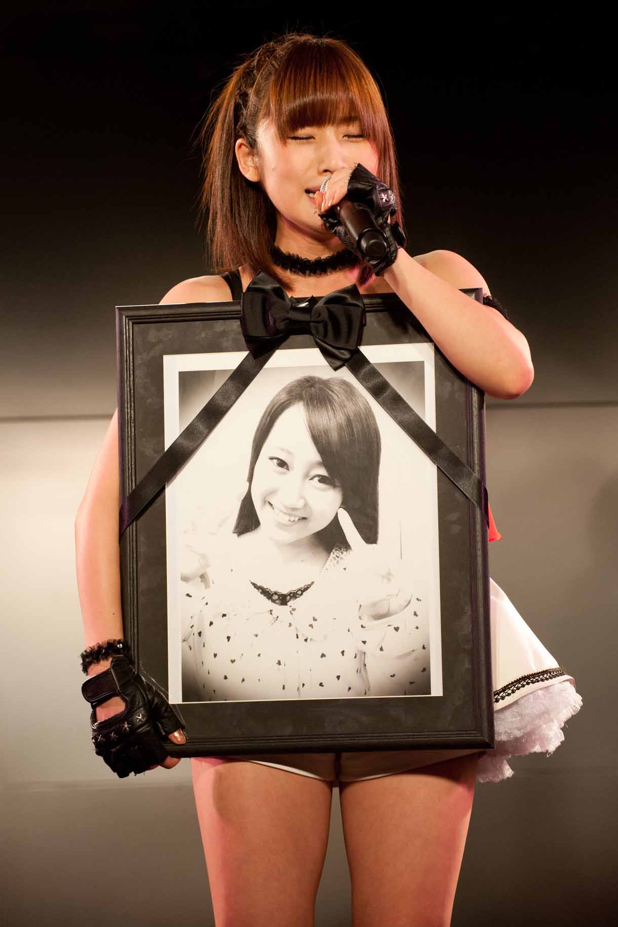古川小夏の遺影を抱える仙石みなみ。