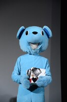 無表情でクマスタープレゼント抽選箱を持つクマスター。