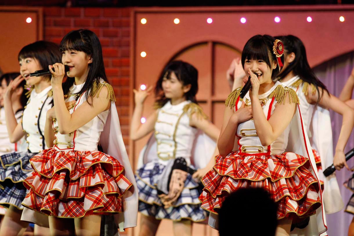 新曲「桜、みんなで食べた」を歌唱する田島芽瑠、朝長美桜（手前左から）。 (c)AKS