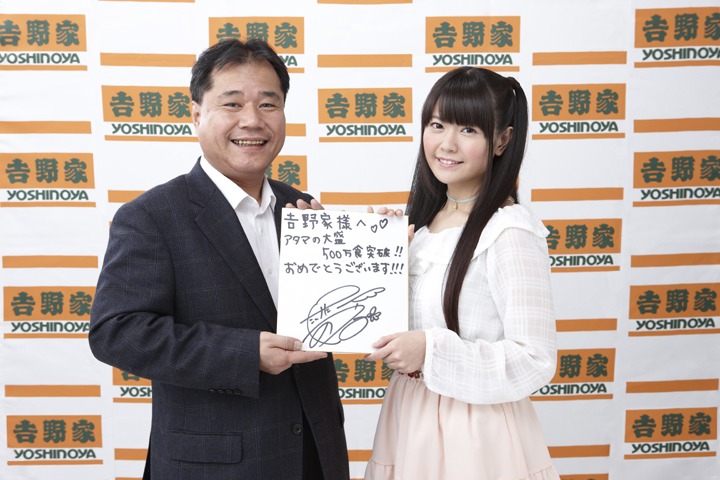 「アタマの大盛」500万食突破を祝してサイン色紙を贈呈する竹達彩奈（右）。