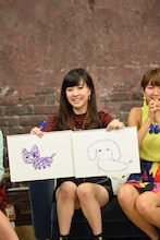 清水佐紀。右手に持っているのが、萩原舞が描いて波紋を呼んだトイプードルの絵。